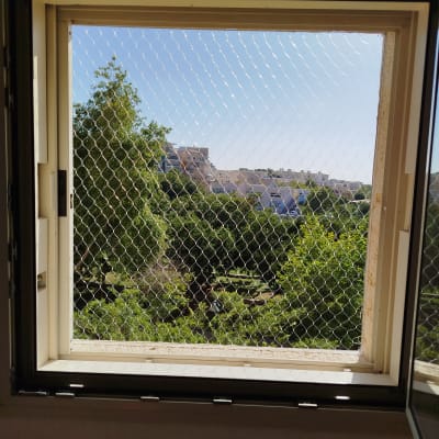 רשת מתכת על חלון למניעת כניסת יונים