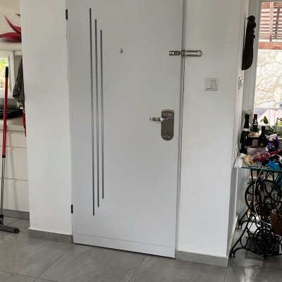 דלת אפורה עם ידית מתכת ועיטורים אנכיים