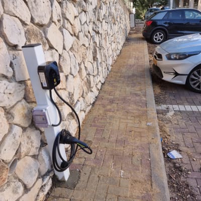 עמדת טעינה לרכב חשמלי ליד מדרכה