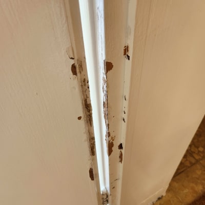 משקוף דלת עם קילופי צבע ועץ חשוף