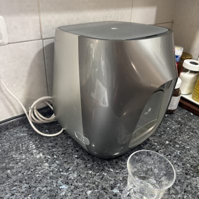 מכונת מים על משטח מטבח עם כוס פלסטיק