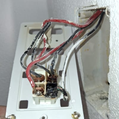 חוטי חשמל אדומים ושחורים מחוברים לשקע