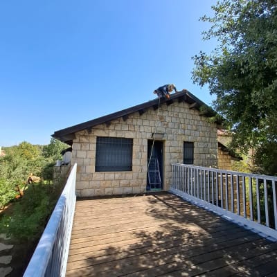 עבודה על גג בית אבן עם פועלים