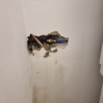 צינור מים חשוף בקיר עם נזילה אפשרית