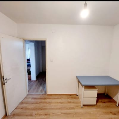 חדר ריק עם שולחן קטן ומנורה תלויה