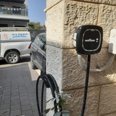 מטען חשמלי לרכב מותקן על קיר אבן