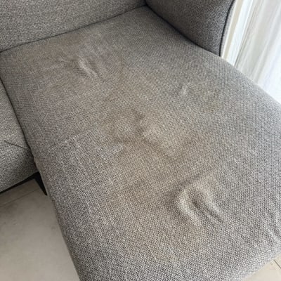 ספה אפורה עם סימני לכלוך קלים