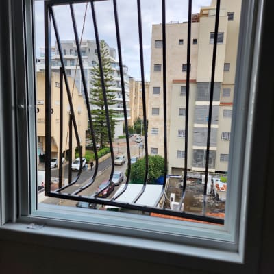 חלון עם סורגים מתכתיים נראים מבחוץ