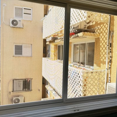 חלון אלומיניום עם מסגרת לבנה ומסך רשת