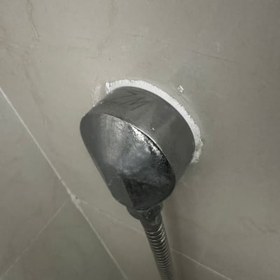 חיבור צינור מתכת לקיר עם סימני רטיבות