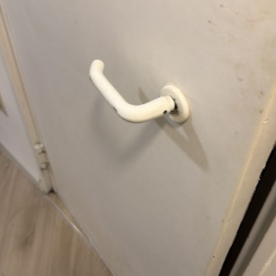 ידית דלת לבנה על דלת בהירה