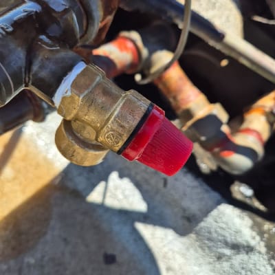 שסתום מתכת עם כובע אדום במערכת חימום