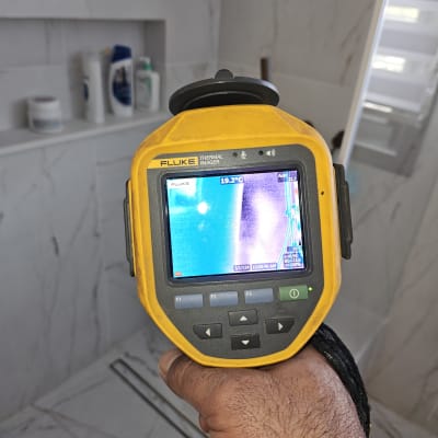 מצלמה תרמית ביד בודקת נזילות בחדר אמבטיה