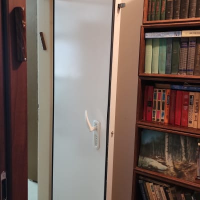 דלת לבנה פתוחה עם ידית ומנעול