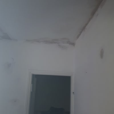 כתמי רטיבות על קיר ותקרה לבנים