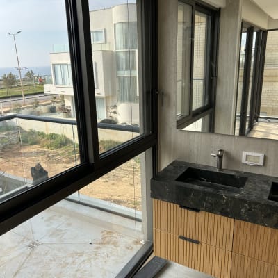 כיור ושיש בחדר עם חלונות גדולים ונוף חיצוני