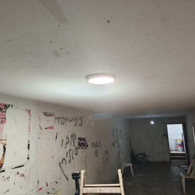 תאורה תקרה עגולה דולקת בחדר עם קירות מלוכלכים