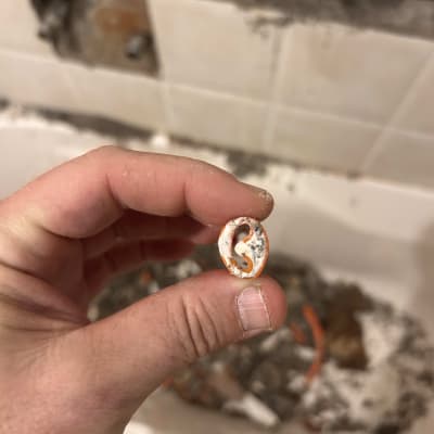 יד מחזיקה חלק פלסטיק קטן בעבודת אינסטלציה