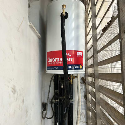 דוד שמש עם צינורות ומחברים מותקנים על קיר