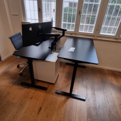 שולחן עבודה עם מחשב ומסך בחדר עם חלונות גדולים