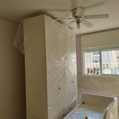 חדר עם רהיטים מכוסים בניילון לקראת צביעה