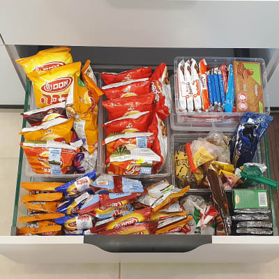 מגירת חטיפים מסודרת עם שקיות וממתקים שונים