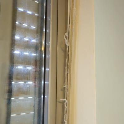 רצועת תריס גלילה ידני שחוקה וקרועה לצד חלון אלומיניום