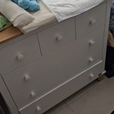 שידה עם מגירות, צעצועים ובגדים על הרצפה