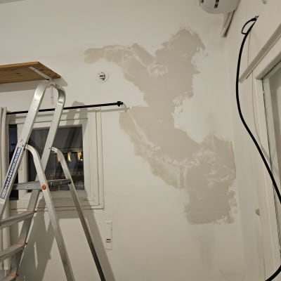 חלון עם תריסים סגורים ליד סולם מתכת