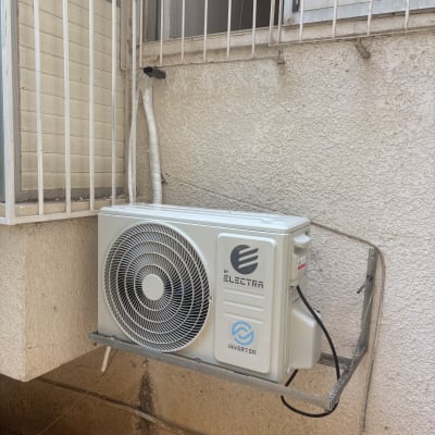 יחידת מזגן מותקנת על קיר חיצוני ליד חלון