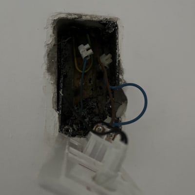 חוטי חשמל מחוברים בתוך קופסת חיבורים בקיר