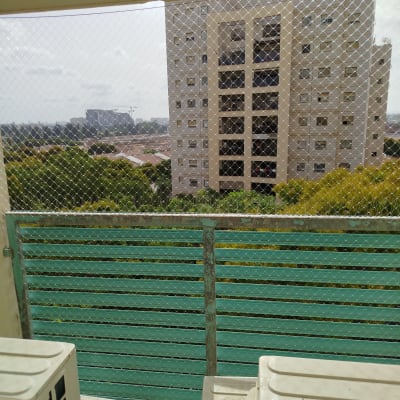 רשת יונים מותקנת על מרפסת עם נוף לבניין מגורים