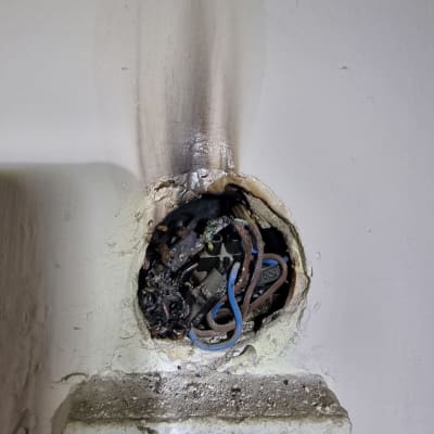 חוטי חשמל שרופים בקיר עם סימני פיח