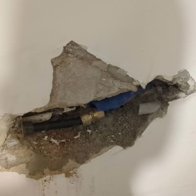 צינור מים חשוף בקיר עם חיבור מתכת