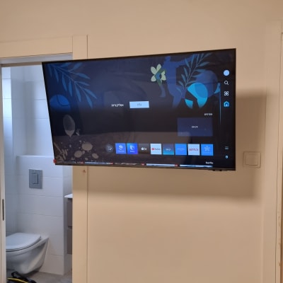 טלוויזיה תלויה על הקיר ליד דלת פתוחה