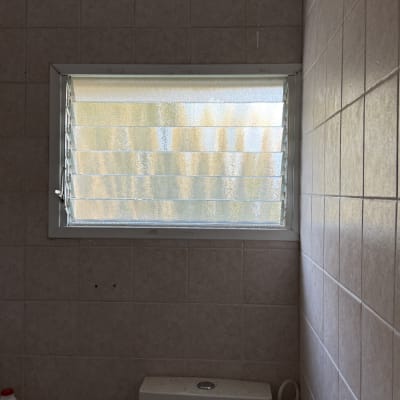 חלון זכוכית עם תריסים בחדר אמבטיה