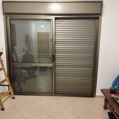 תריסים סגורים על חלון זכוכית בחדר פנימי