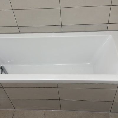 אמבטיה לבנה עם אריחי קרמיקה מסביב