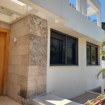 חלונות אלומיניום כהים על קיר חיצוני של מבנה מודרני