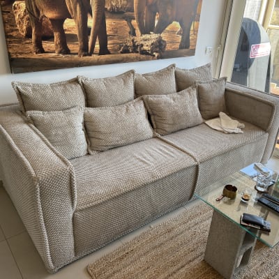 ספה עם כריות ושולחן זכוכית עם חפצים