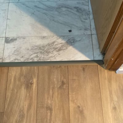 חיבור בין פרקט עץ לרצפת שיש בכניסה לחדר