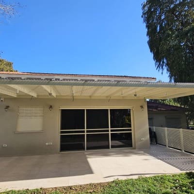 פרגולה מאלומיניום מחוברת לקיר חיצוני של בית