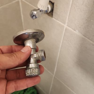 ברז וצינור מים על קיר אריחים