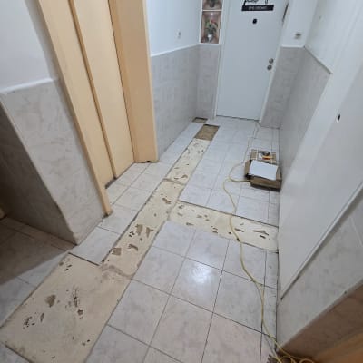 מסדרון עם רצפה בתהליך שיפוץ, אריחים חסרים