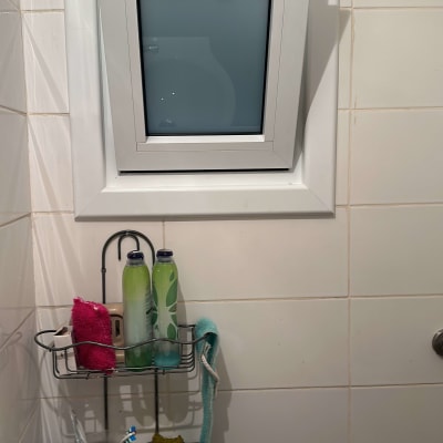 חלון קטן עם תריסים סגורים בחדר אמבטיה