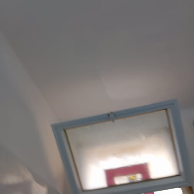 חלון עם מסגרת צבעונית על קיר צבוע