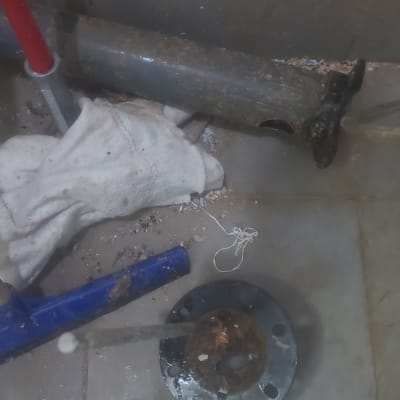 כלים וחלקים על רצפה רטובה, כולל צינור ומתכת