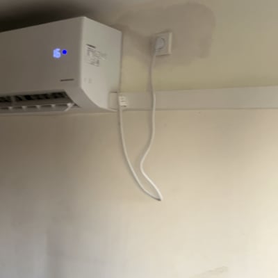 מזגן מותקן על קיר עם כבל חשמל מחובר