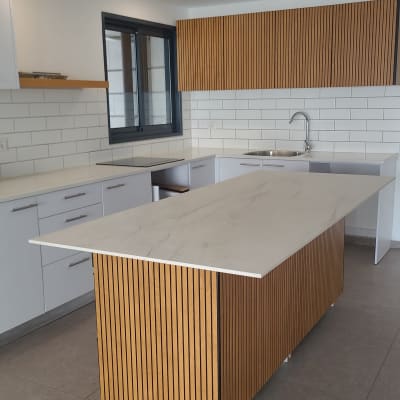 מטבח נקי עם משטחי שיש וכיור נירוסטה