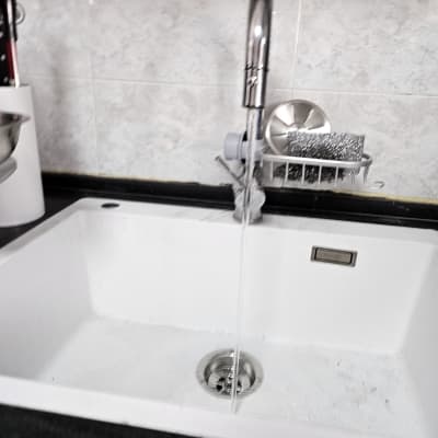 ברז מים זורם בכיור מטבח לבן